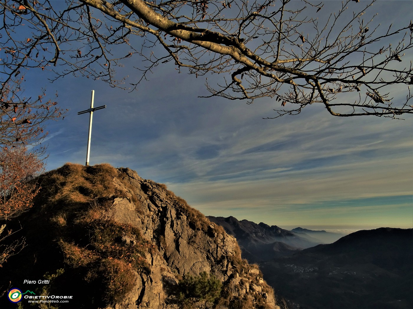 73 Il cocuzzolo roccioso con la croce baciato dal sole che volge al tramonto.JPG